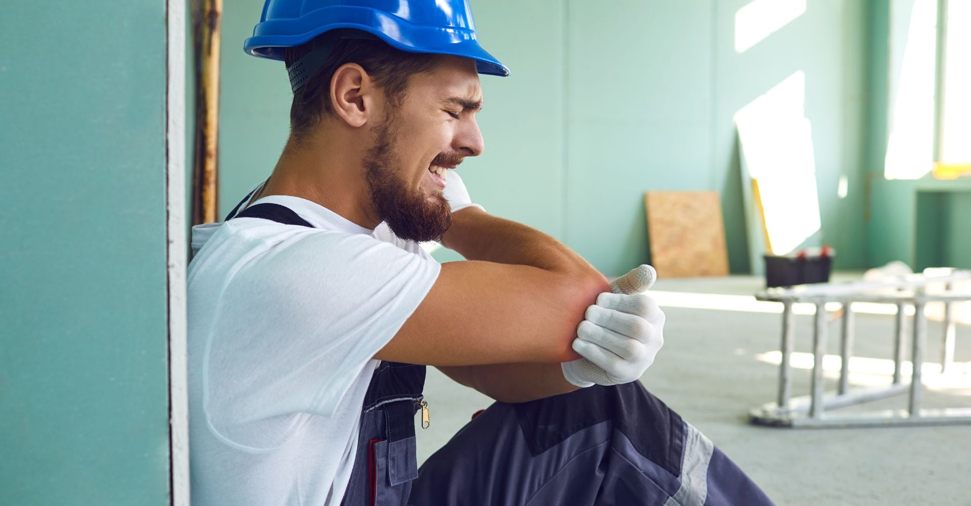 Un ouvrier qui a mal au coude sur un chantier