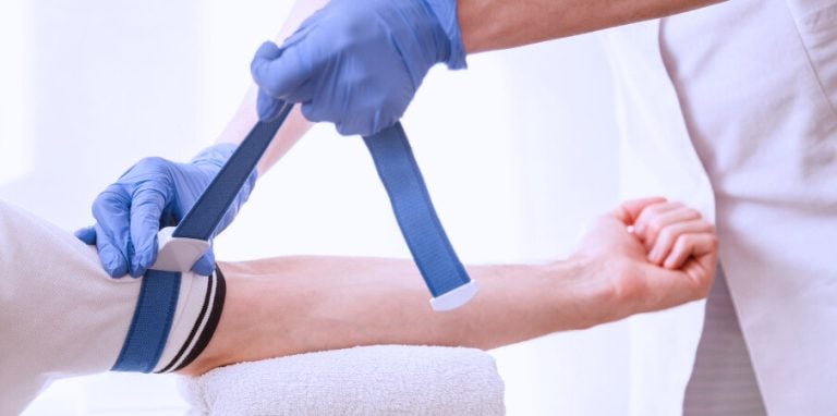 Mise en place d'un garrot infirmier par un professionnel de santé sur le bras d'un patient