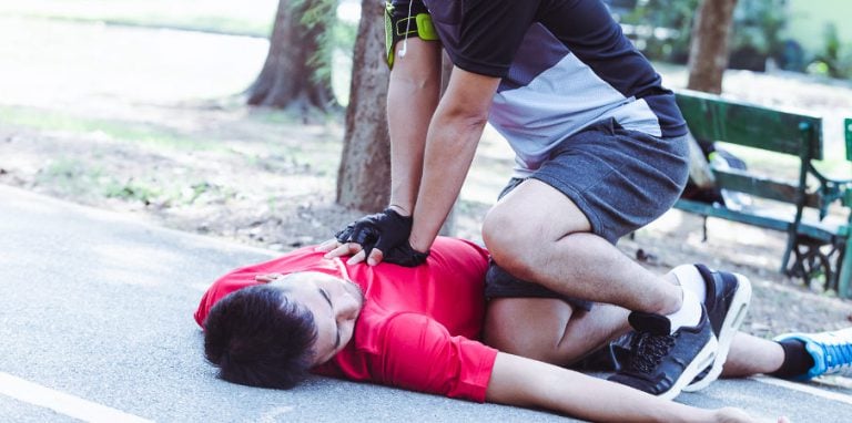 personne pratiquant un massage cardiaque sur une personne en arrêt cardiaque