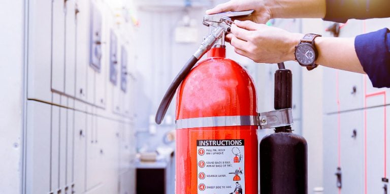 Technicien en train de contrôler un extincteur