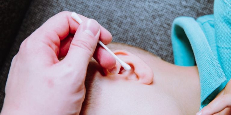 adulte en train d'ôter un corps étranger dans l'oreille d'un enfant