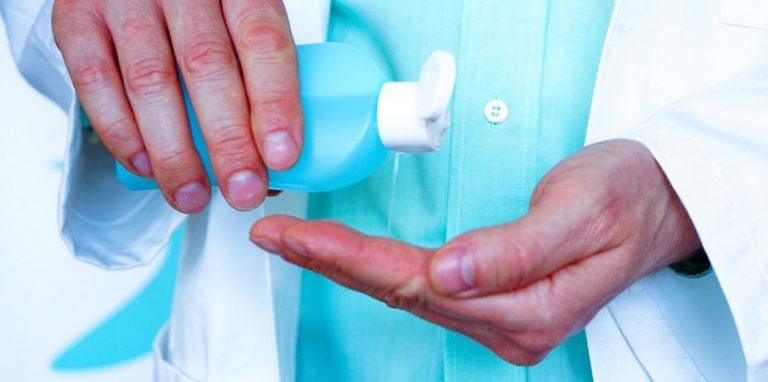 soignant en train d'appliquer un produit pour la desinfection des mains