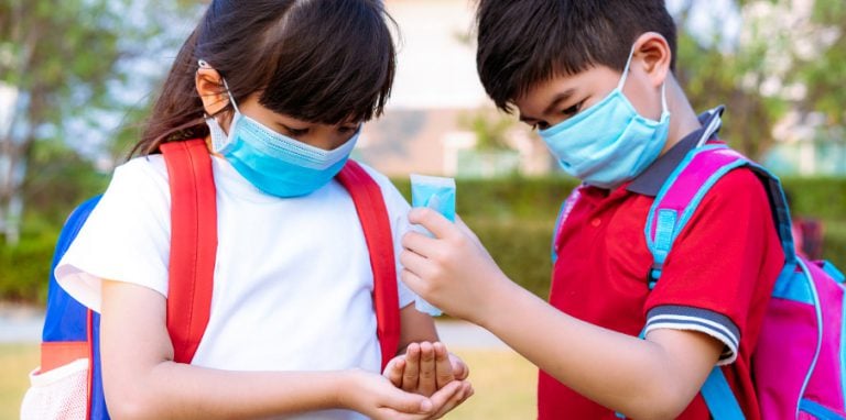 élèves en train d'appliquer des gestes d'hygiène à l'école