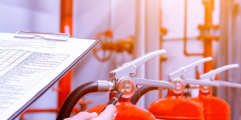 technicien pratiquant la maintenance d'un extincteur