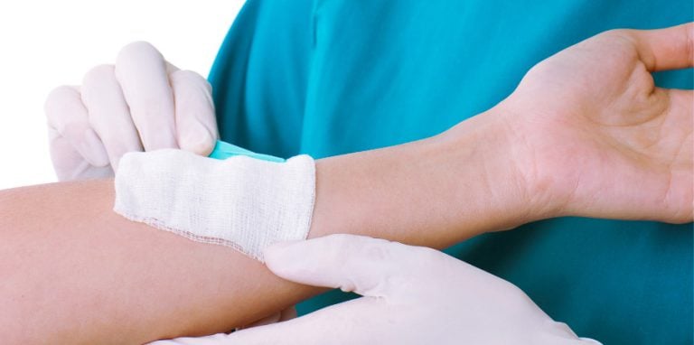 Infirmière posant une compresse sterile sur une patiente