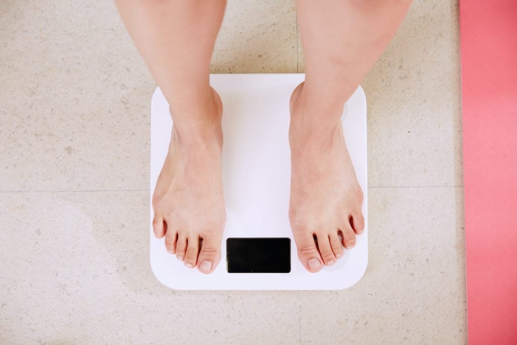 femme en train de se peser sur une balance électronique