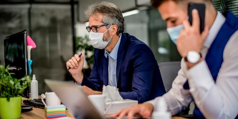 employés au bureau portant un masque